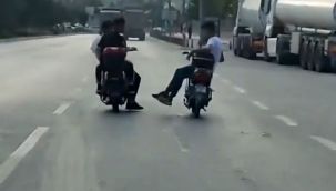 Elektrikli motosiklete yan oturan sürücünün tehlikeli yolculuğu